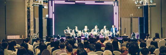 Rear view of Asian audience joining and listening group of speaker talking on the stage in the seminar meeting room or conference hall, business and education, associate and startup business concept