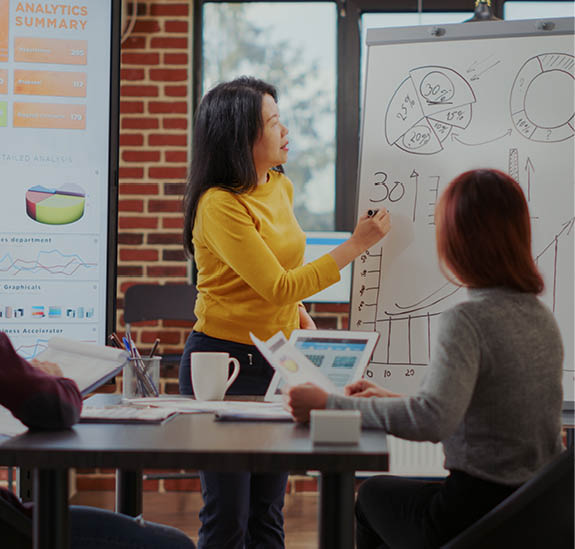 Multi ethnic team meeting in boardroom to discuss presentation with graphs for business growth. Workmates working together to plan financial development and e commerce success.